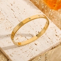 18k gold plated stainless steel star bangle with crystals on beige stone background - Gold