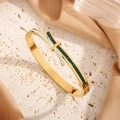 Gold titanium steel bow bracelet featuring green rectangular stones and crystal accents - Gold Green Zirconia