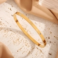 Polished gold titanium steel double heart bangle featuring two sparkling zircon accents - Gold