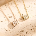 Collana minimalista in acciaio al titanio con ciondolo a cilindro e zirconi in oro e rosa - Oro