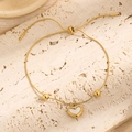 Elegant adjustable gold heart bracelet with white shell inlay on a natural stone surface - Heart White Shell Bracelet