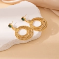 Detail of gold layered hoop earrings with green stone on white stone background - Green Zircon Multilayer Circle Stud Earrings (1991)