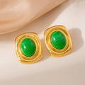 Primer plano de pendientes vintage bañados en oro con resina verde en seda champán - Pendiente de Piedra Verde Cuadrado 1972