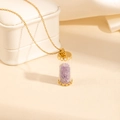 Detail showing a gold cylinder pendant filled with purple crystals on a cross chain necklace - Purple Stone Style (0840)
