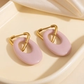 Boucles d'oreilles triangles dorées avec pendentifs ovales en résine rose sur satin beige - Violet