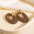 Détail de boucles d'oreilles triangles dorées avec pendentif ovale marron sur soie - Marron