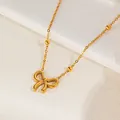 Golden bow pendant necklace with small solid beads on a stone tray backdrop - Gold Bowknot Round Bead