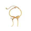 Detail einer goldenen Schlangenkette mit Schleifen-Anhänger und verstellbarem Verschluss - Schleife Armband / Gold