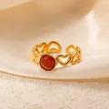 Close-up of golden heart-shaped open ring with an orange cat-eye stone detail - Openwork Heart Red-Orange Stone Adjustable Style (TYR1019)