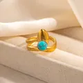 Detail of gold-plated crossover ring featuring a turquoise stone and teardrop metal element - Cross Design Blue Green Stone Style (R1209)