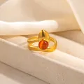 Detail of a layered gold ring with a teardrop charm and orange cat-eye gemstone - Layered Band Orange Stone Style (R1208)