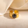 Close-up of a gold hammered stainless steel ring featuring a black oval gemstone inlay - Black (R1249)