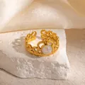Close-up of a gold crown ring with a pearl inlay on a soft silk background - Crown Design Iridescent White Stone Adjustable Style (TYR1344)