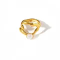 Dettaglio macro di un anello in metallo liquido dorato con perla bianca aurora tonda - Stile Cabochon Bianco Perlato (R1483)