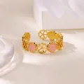 Detail of pink zircon heart flower patterns on golden stainless steel open ring - Hollow Flower Heart Pink Enamel Style (G128098-t)