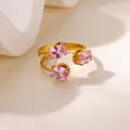 Close-up of pink oval gemstones on a gold adjustable stainless steel heart flower ring - Triple Oval Pink Stone Style (G128450)