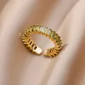 Macro shot of 18K gold-plated baguette-cut green zircon ring on champagne silk fabric - Pave Baguette Olive Green Style (JZ4470G-5)