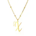 Macro shot of gold letter X pendant with butterfly wing detail and beaded chain - Letter X Style