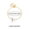 Elegant gold titanium bracelet featuring white flower charm and adjustable chain link - White Shell Flower Bracelet (0193)