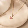 Elegante gouden zeester hanger ketting met paars emaille detail op een schaal - Paarse Zeester