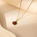 Vergoldete Halskette mit rundem rotem Anhänger und schwarzer Palmen-Silhouette im Design - Palmen-Design
