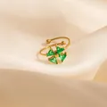 Golden open ring featuring four green triangular gemstones in a windmill floral design - Green Windmill Style (1649)