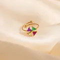 Macro shot of an adjustable gold ring with four multi-color triangle gemstones on silk - Colorful Windmill Style (1648)