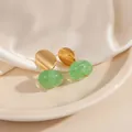 Boucles d'oreilles ovales dorées avec pierre vert clair sur fond de soie blanche - Boucles d'oreilles clous en pierre ovale (1801)
