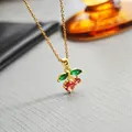 Golden cherry pendant necklace with red gemstones and green leaves on a thin chain - Red Cherry Necklace 0368