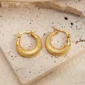 Twisted gold hoop earrings with waffle texture pattern on light stone surface - Grid Pattern Round Earrings 0244