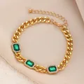 Detail eines vergoldeten Panzerarmbands mit drei grünen Steinen und weißen Mikro-Zirkonia - Goldenes Strass-Smaragd-Armband (A-1001)