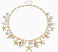 Collana bohémien dorata con conchiglie marine, perle e stelle marine su sfondo bianco - Collana Oceano Multielemento Oro KC (3255)
