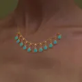 Bohemian gold necklace with evil eye turquoise pendants worn by a model in a lifestyle shot - Multi-Teardrop Linked Style (6332)