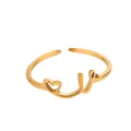 Détail d'une bague dorée ajustable avec cœur évidé et lettrage Love manuscrit - Lettre V