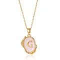 Close-up of 18K gold plated letter G pendant with pink enamel and irregular texture - Gold G