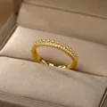 Detalle del anillo eternity dorado con pavé de circonitas y borde de cuentas artesanales - Estilo De Eternidad De Corte Baguette (G9102482G-5-t)