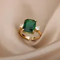 Close-up of vintage 18K gold plated ring with emerald green zircon and three-stone design - Emerald Rectangle With Side Stones Style (G6223761)