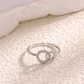 Macro detail of intertwined silver rings featuring pavé set cubic zirconia and polished bands - Platinum