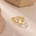 Macro shot of interlocking golden double rings featuring zircon pave on textured stone - Gold (G9128545)