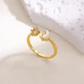Gros plan détaillé d'une bague étoile et lune dorée avec cristaux sur pierre blanche - Ouvert Réglable / Style Étoile Lune Dorée Zirconia Nacre (G7247505)