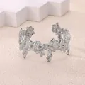 Dettaglio macro del bracciale rigido argento geometrico con design aperto a forma di fiocco - Stile Fiocco Metallo Liquido (P10302159)