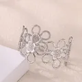 Detail view of a silver floral open bangle with hollow petals and a matte metallic finish - Hollow Flower Style (P10302187) / Silver