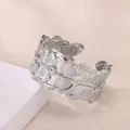 Macro shot of silver metal cuff bracelet featuring detailed interlocking butterfly motifs - Butterfly Style (P10302152) / Silver