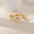 Detail of copper gold ring with butterfly zircon inlay and cat eye stone on white blocks - White Cat Eye Butterfly Style (G1228439)