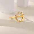 Close-up of golden multi-layered ring with sparkling zircon stones on minimalist blocks - Hollow Circle Minimalist Style (G1228557)