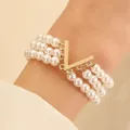 Bracelet trois rangs en perles avec breloque dorée en V pour un style femme élégant - Pendentif Lettre V en Perle à Trois Couches (5224)