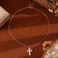 Macro shot of gold cross necklace with micro-paved zircons on brown velvet texture - KC Gold 6679 Gold Large Cross Zircon Pendant Necklace