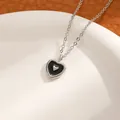 Elegant silver necklace featuring a black heart pendant with a small silver heart inlay - White K Black Heart Necklace