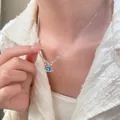 Silver clavicle necklace with blue heart gemstone and planet ring pendant on model - Butterfly Heart Planet Style / Silver Blue