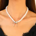 Elegant pearl necklace featuring a silver bow pendant worn by a model in black lace - Single Bow Pearl Necklace (N-096) / Silver/White